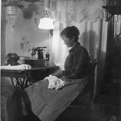 Foto einer Heimarbeiterin um 1928, Abbildung in der Publikation Am Küchentisch - Heimarbeit und Hausindustrie im Wandel der Zeit