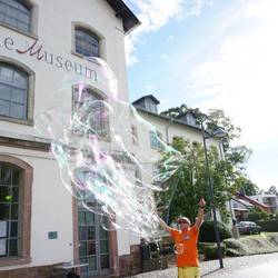 ein Seifenblasenkünstler vor dem Esche-Museum